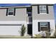 Two-story house with gray siding, white garage door, and landscaping at 196 Albany Dr, Kissimmee, FL 34759