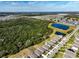 Aerial view of homes and a large undeveloped area with trees and a pond at 2124 Live Oak Lake Rd, St Cloud, FL 34771