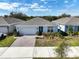 Single-story home with gray roof, white garage door, and landscaped yard at 2124 Live Oak Lake Rd, St Cloud, FL 34771