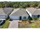 Single-story home with gray roof, white garage door, and landscaped yard at 2124 Live Oak Lake Rd, St Cloud, FL 34771