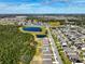 Aerial view of homes and a large undeveloped area with trees and a pond at 2124 Live Oak Lake Rd, St Cloud, FL 34771