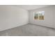 Well-lit bedroom with neutral walls and gray carpeting, featuring a window at 2124 Live Oak Lake Rd, St Cloud, FL 34771