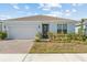 One-story home with light-blue exterior, brick driveway, and landscaped lawn at 2124 Live Oak Lake Rd, St Cloud, FL 34771