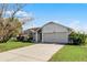 Front view of a single-story house with a two-car garage at 2302 Aberdeen Ct, Kissimmee, FL 34743