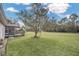 Large backyard with grassy area and mature tree at 2404 Huron Cir, Kissimmee, FL 34746