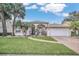 One story house with a tile roof, palm trees and a brick driveway at 2404 Huron Cir, Kissimmee, FL 34746