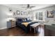 Main bedroom with dark wood floors, a blue comforter, and a gray dresser at 2452 Sweetwater Club Cir # 27, Kissimmee, FL 34746
