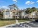 Two-story condo building with yellow exterior and palm trees at 2452 Sweetwater Club Cir # 27, Kissimmee, FL 34746