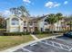 Condo building exterior with landscaping and parking at 2452 Sweetwater Club Cir # 27, Kissimmee, FL 34746