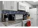 Kitchen features granite countertops, white cabinets, and black appliances at 2452 Sweetwater Club Cir # 27, Kissimmee, FL 34746