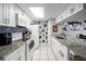 White kitchen with granite counters, blue tile backsplash, and stainless steel appliances at 2452 Sweetwater Club Cir # 27, Kissimmee, FL 34746