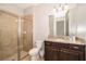 Bathroom with shower, granite countertop, and dark wood cabinets at 250 Pendant Ct, Kissimmee, FL 34747
