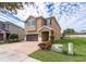 Tan two-story house with brown garage door and landscaping at 250 Pendant Ct, Kissimmee, FL 34747