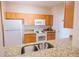 Kitchen with granite counters, wood cabinets, and appliances at 2774 Almaton Loop # 305, Kissimmee, FL 34747