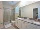 Modern bathroom with double vanity, glass-enclosed shower, and neutral color palette at 2797 Bookmark Dr, Kissimmee, FL 34746