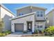 Modern two-story home features a stone facade, gray siding, and a one-car garage at 2797 Bookmark Dr, Kissimmee, FL 34746
