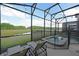 A screened-in pool and lounge chairs provide a relaxing view of the pond at 2797 Bookmark Dr, Kissimmee, FL 34746