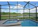 A screened-in pool and spa offer a relaxing oasis with a tranquil view of a lake at 2797 Bookmark Dr, Kissimmee, FL 34746