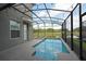 Relaxing screened-in pool area with a view of the lush green landscape and serene pond at 2797 Bookmark Dr, Kissimmee, FL 34746