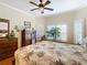 Bedroom with tropical bedding, ceiling fan, and large window with plantation shutters at 301 Anastasia Dr, Kissimmee, FL 34759