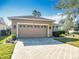 Tan two-car garage with brick paver driveway at 301 Anastasia Dr, Kissimmee, FL 34759