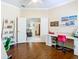 Home office with wood floors, desk, and view into adjacent living space at 301 Anastasia Dr, Kissimmee, FL 34759