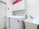Bright laundry room with washer, dryer, and extra cabinets at 301 Anastasia Dr, Kissimmee, FL 34759