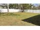 Large, grassy backyard enclosed by a pristine white fence, offering privacy and space at 3839 Se 132Nd Pl, Belleview, FL 34420