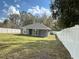 Picturesque backyard featuring green grass and a white fence, ideal for entertaining or enjoying quiet moments at 3839 Se 132Nd Pl, Belleview, FL 34420