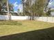 Spacious backyard with vibrant green grass and a stylish white fence, creating a private oasis at 3839 Se 132Nd Pl, Belleview, FL 34420