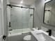 Updated bathroom showcasing marble-look tile, modern black hardware, and a sleek glass shower door at 3839 Se 132Nd Pl, Belleview, FL 34420