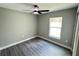 Bedroom showcasing wood-look floors, a ceiling fan, and a bright window providing ample natural light at 3839 Se 132Nd Pl, Belleview, FL 34420