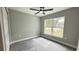 This bedroom features a ceiling fan, natural light from the window, and sleek gray wood-look flooring at 3839 Se 132Nd Pl, Belleview, FL 34420