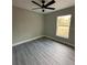 Bright bedroom featuring gray walls, ceiling fan, and gray vinyl plank flooring at 3839 Se 132Nd Pl, Belleview, FL 34420