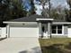 Charming single-story home featuring a two-car garage and manicured lawn at 3839 Se 132Nd Pl, Belleview, FL 34420