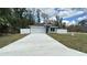 Inviting home with a spacious driveway, well-manicured lawn, and stylish exterior design at 3839 Se 132Nd Pl, Belleview, FL 34420