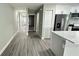 Open hallway with gray flooring leading to the front door and kitchen area at 3839 Se 132Nd Pl, Belleview, FL 34420