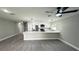 Bright, open-concept kitchen features stainless steel appliances, quartz counters, and sleek white cabinets at 3839 Se 132Nd Pl, Belleview, FL 34420