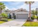 One story house with light brown siding, a two-car garage, and manicured landscaping at 4483 Casablanca Ave, Kissimmee, FL 34746