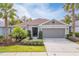 One-story house with light brown siding, a two-car garage, and a landscaped front yard at 4483 Casablanca Ave, Kissimmee, FL 34746