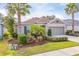 One-story house with light brown siding, two-car garage, and lush landscaping at 4483 Casablanca Ave, Kissimmee, FL 34746