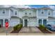 Three-story townhome with two-car garage and landscaped front yard at 4806 Tribute Trl, Kissimmee, FL 34746