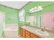Bathroom with double sinks, bathtub, and green walls at 4878 Zion Dr, St Cloud, FL 34772
