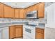 Kitchen features white appliances and wood cabinets at 4878 Zion Dr, St Cloud, FL 34772