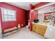 Bathroom with red walls, wood vanity, and white tile floor at 4999 Disston Dr, St Cloud, FL 34771