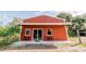 Charming exterior view of a bright red home with a concrete porch and lush landscaping at 4999 Disston Dr, St Cloud, FL 34771