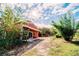 Scenic exterior view of a red home with well-maintained grounds and a long private driveway at 4999 Disston Dr, St Cloud, FL 34771