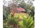 Red house with lush landscaping, offering a charming curb appeal at 4999 Disston Dr, St Cloud, FL 34771