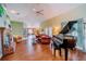 Spacious living room featuring vaulted ceilings, hardwood floors, a grand piano, and cozy fireplace at 4999 Disston Dr, St Cloud, FL 34771