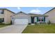 One-story house with gray siding, white garage door, and teal shutters at 5384 Hickory Downs Way, St Cloud, FL 34771